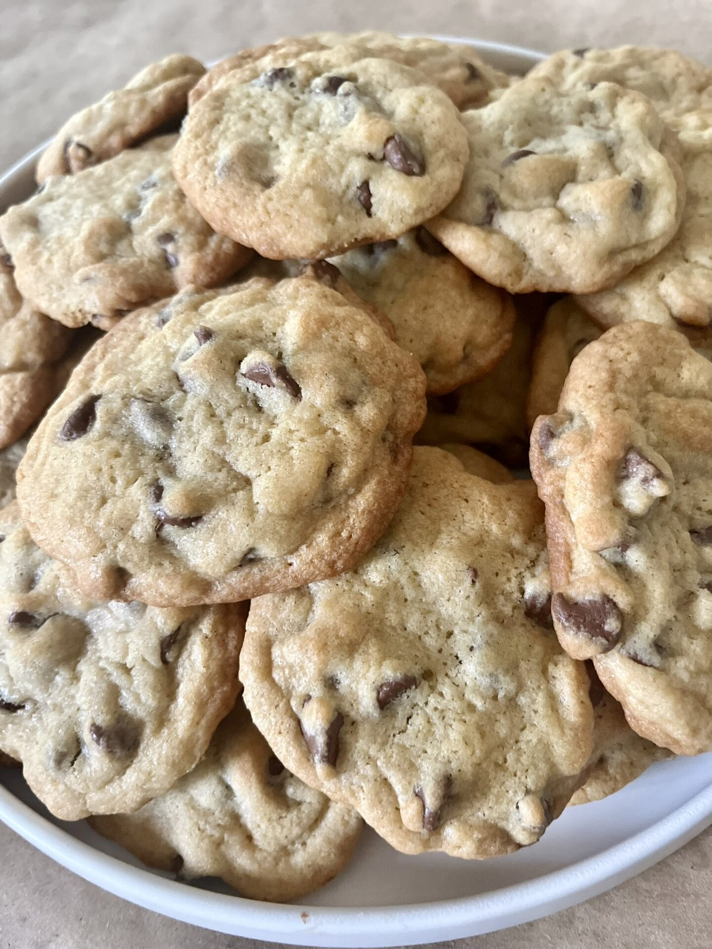 A plate of freshly baked homemade chocolate chip cookies, golden brown with gooey chocolate chips, ready to enjoy.