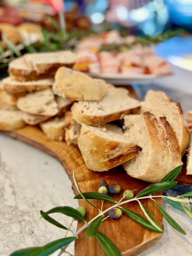 Golden homemade sourdough bread with a crispy crust and soft, airy interior, freshly sliced on a wooden cutting board